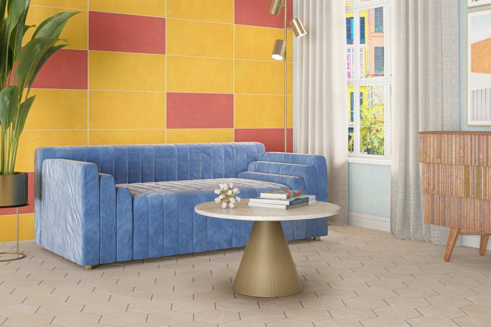 hexagon tile floor in living room with bright blue couch and retro tiled wall